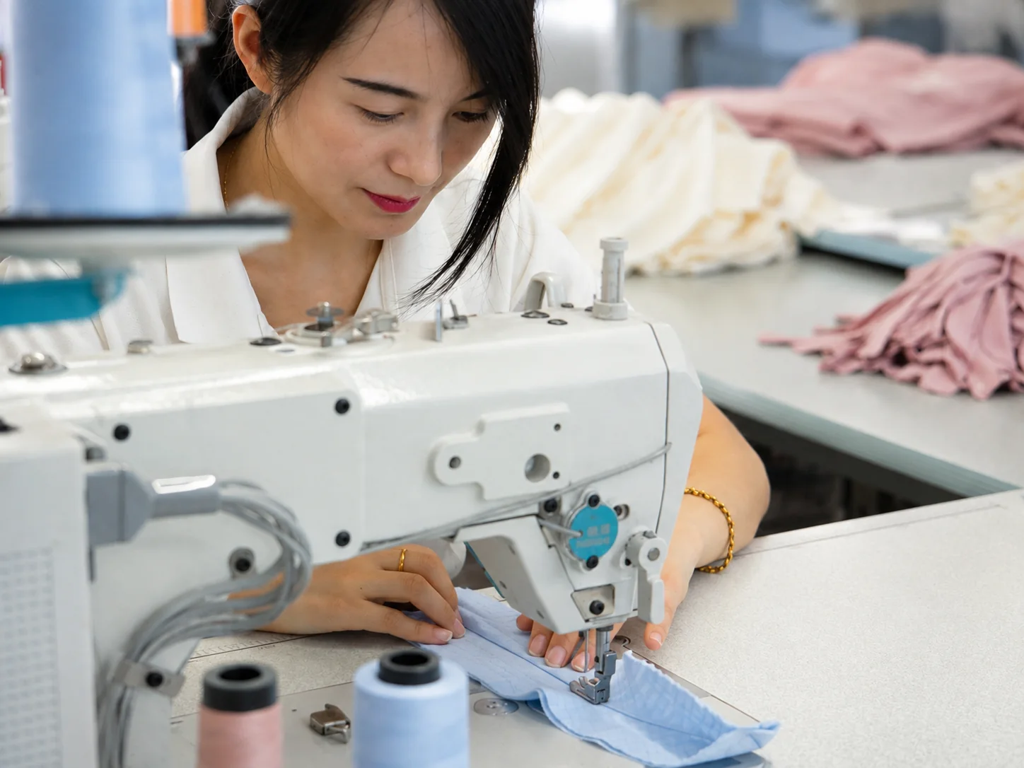 Worker sewing garment detail